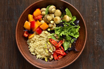 Salad with quinoa, sweet pepper, mushrooms, herbs and pistachios. Healthy nutrition. Vegetarian concept, top view