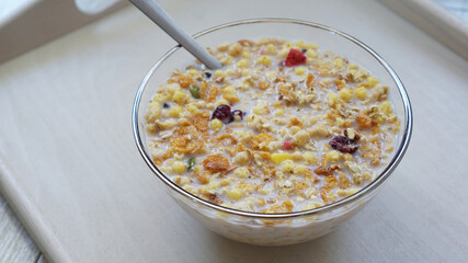 スプーンの添えられたグラノーラが中心に置かれた写真