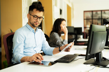 Young businessman using laptop in his office. Handsome man working on laptop.
