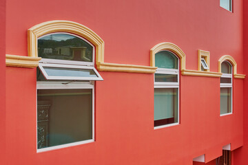 Fachada de hotel color salmón con ventanas simétricas y balcones