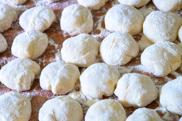 Fototapeta na wymiar Three balls of fresh homemade wheat dough on kitchen table