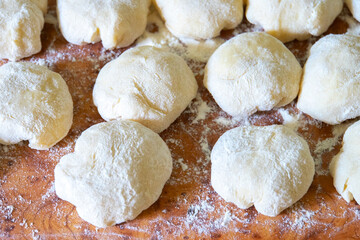 Three balls of fresh homemade wheat dough on kitchen table