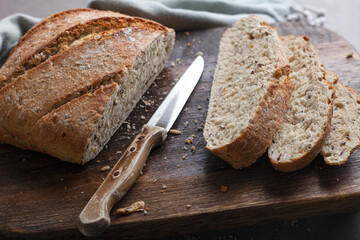 Fresh bread slice and cutting knife on table