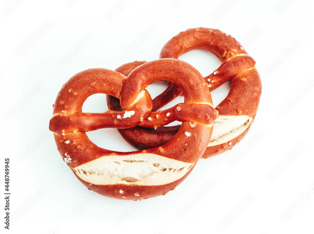 Wall mural Two traditional Bavarian pastry Bretzes, beer snack. German salty bakery pretzel, isolated on white background.