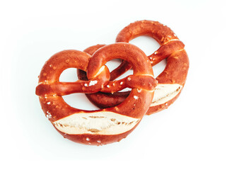 Two traditional Bavarian pastry Bretzes, beer snack. German salty bakery pretzel, isolated on white background.