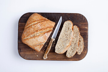 Fresh bread slice and cutting knife on table