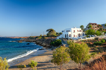 Fototapeta na wymiar Beautiful whitewashed house facing the Aegean Sea in Moutsouna beach. Moutsouna is a tiny, picturesque fishing village in the island of Naxos, Cyclades, Greece.