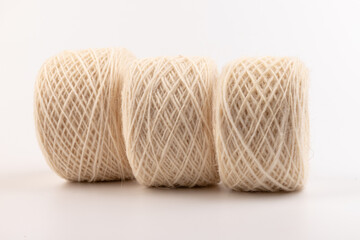 balls of light woolen thread on white background. natural wool. knitting. background