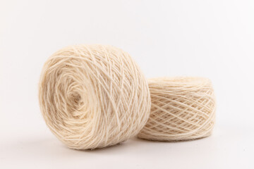 balls of light woolen thread on white background. natural wool. knitting. background