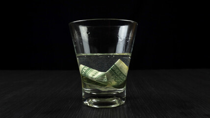 Soak US Dollars in a glass filled with isopropyl alcohol and water. The science concept of burning money without damage