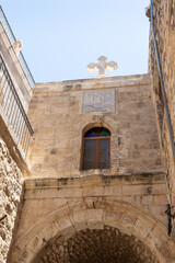 Fototapeta na wymiar Large white stone cross on the roof of the building on the Greek Patriarchate Street in Christian quarters in the old city of Jerusalem, Israel