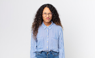 pretty hispanic woman looking goofy and funny with a silly cross-eyed expression, joking and...