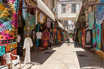 Decorative bedspreads and other souvenirs are sold on Al Souq Street in Muristan, in Christian...