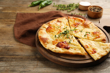 Delicious khachapuri with cheese on wooden table
