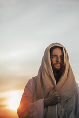 Portrait of Jesus Christ in white robe at sunset.
