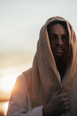 Portrait of Jesus Christ in white robe at sunset.