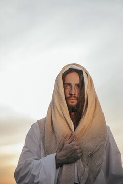 Portrait of Jesus Christ in white robe against sky.