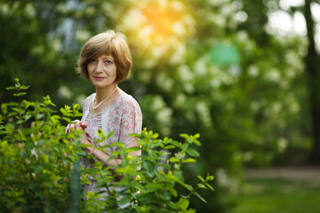Beautiful slender woman stands in a summer garden