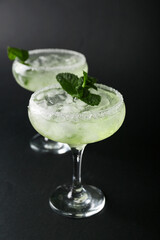 Glasses of cold daiquiri cocktail on dark background