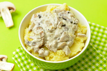 Bowl with tasty mashed potatoes and mushrooms on color background
