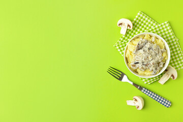 Bowl with tasty mashed potatoes and mushrooms on color background