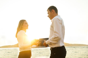 well dressed Couple using a laptop on an outdoor terrace of a restaurant. Business people.