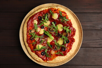 Pita pizza with cheese, olives, mushrooms and arugula on wooden table, top view