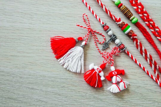 Bulgarian traditional spring decor martenitsa bracelets, wooden background. Baba Marta holiday, backdrop.