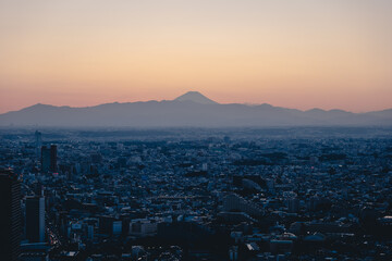 日が落ちたばかりの富士山のシルエットと渋谷の街並み