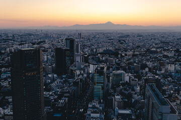 渋谷の屋上から見た、日の入り直後の富士山のシルエットと街並み