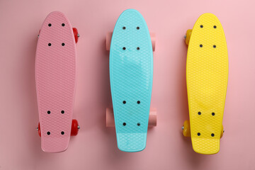 Color skateboards on pink background, flat lay