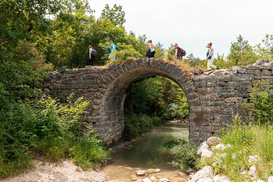 Tourists walks across the Napoleon's Bridge over the Mirna river in Istria, Croatia