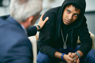 Sad African American teenager on individual session with psychotherapist at counselling center.