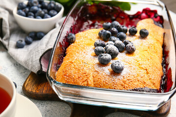Baking dish with blueberry cobbler on light background, closeup