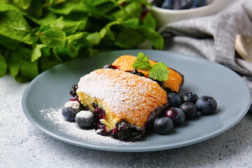 Plate with pieces of blueberry cobbler on light background, closeup