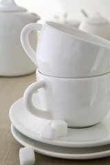 Xícaras e pires brancos em mesa de café da manhã 