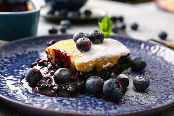 Plate with piece of blueberry cobbler on table, closeup
