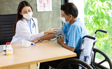 Young asian woman doctor encouragement and supportive to cansor patient after consult and examine in clinic hospital health ideas concept. Problem talk at medical checkup visit with wheelchair .