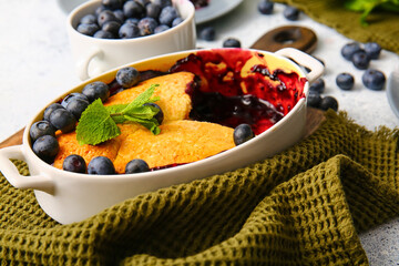 Baking dish with blueberry cobbler on table, closeup