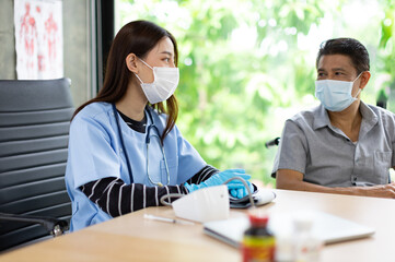 Young asian woman doctor encouragement and supportive to cansor patient after consult and examine in clinic hospital health ideas concept. Problem talk at medical checkup visit with wheelchair .