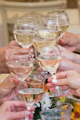Hands with glasses of champagne wine, happy people celebrate christmas