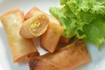 deep fried spring roll stuffed glass noodles with lettuce dipping sweet chili sauce on dish