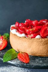 Board with tasty strawberry pie on dark background, closeup