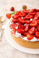 Plate with tasty strawberry pie on light background, closeup