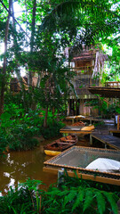 June 30 2021, Ranong, Thailand : Top view in nature with relax seat and wooden boat at cafe and restaurant at Baan Rai Irun, Ranong, Thailand.