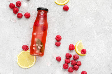 Bottle with tasty raspberry lemonade  on light background