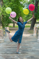 Young woman with colorful air balloons outdoors, happiness concept.
