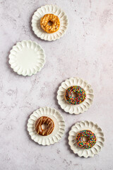 Doughnuts with sprinkles on decorative scallop ceramic plates