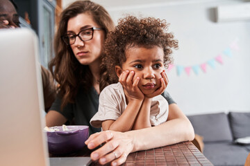 Girl looking with bored emotions while showing to parents that she does not want to eat