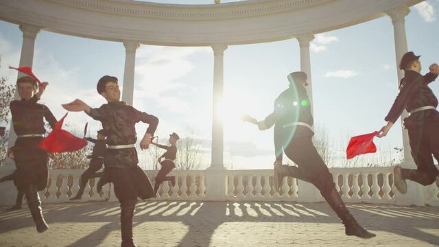 4K Group of Caucasian dancers in local black costumes perform traditional folk dance . Group of Men dancing traditional dance with handkerchief . Outdoor Shot on RED EPIC DRAGON Cinema Camera .